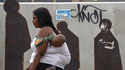 People walk along a downtown street in Johannesburg, South Africa, Monday, March 16, 2020. Millions of women and girls globally have lost access to contraceptives, abortion services and related care because of the coronavirus pandemic.