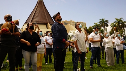 Group of people gather outside a church for a prayers