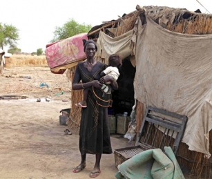 A woman stands outside her home in Wunchuei, near the contested region of Abyei, Sudan and South Sudan's new and undefined border.