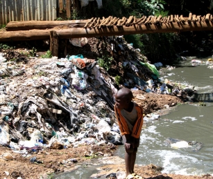 Child in trash strewn Kibera slum.