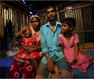 Mahe Noor, left, and Nizam Hawladar with two of their children in Dhaka, Bangladesh. A cyclone two years ago uprooted them from a village where they had their livelihood.