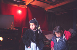 Photo: Two girls look out the open door of a makeshift house in the Roma (or Gyspy) settlement of Vaulx-en-Velin, France