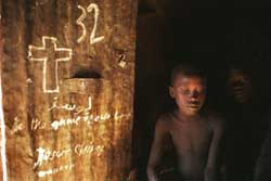 Two children sit next to Christian graffiti